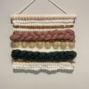 a mini woven wall hanging featuring golden yellow, fir green, sage khaki and mauve.