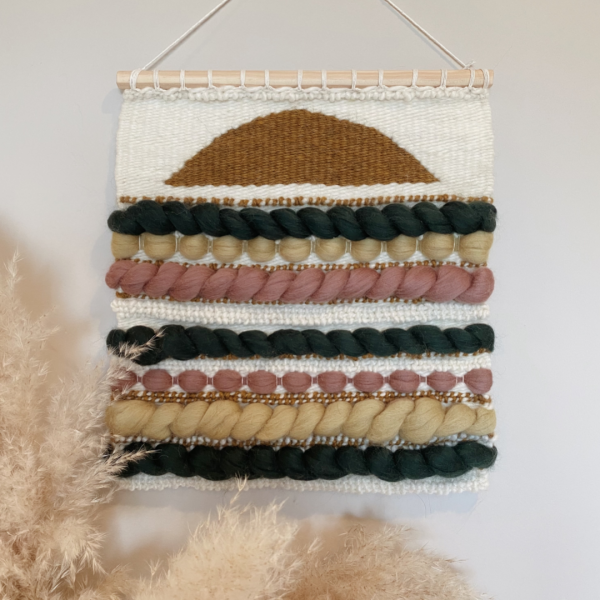 a woven wall hanging featuring golden yellow, fir green, sage khaki and mauve.